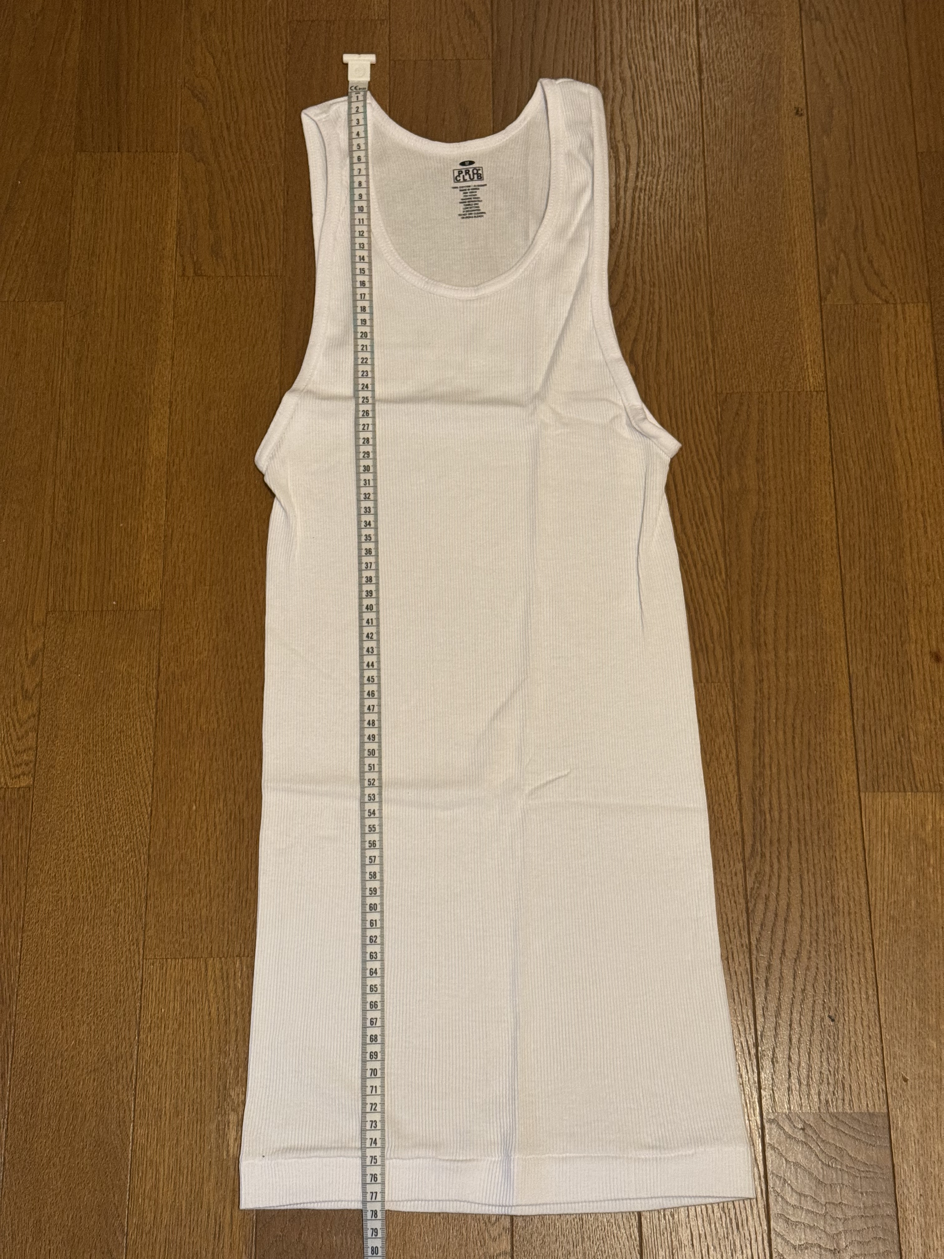 Pro Club 5.7ozタンクトップ 未洗状態の着丈を計測している画像(77cm)
