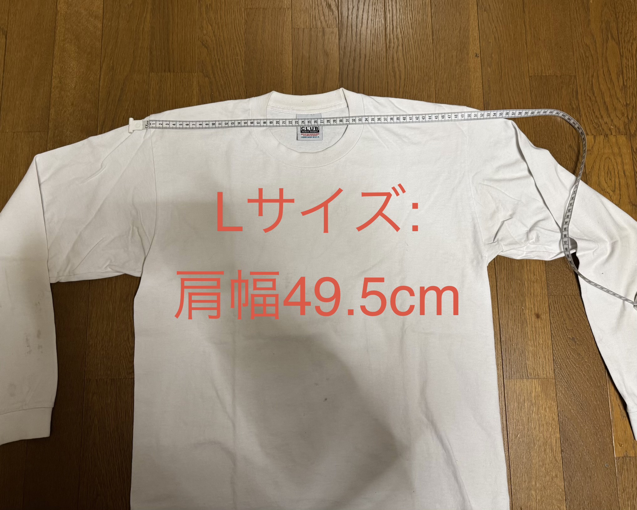 プロクラブ・ヘビーウェイト・ロンT（Lサイズ）の肩幅を計測している様子。メジャーの数値は49.5cm。