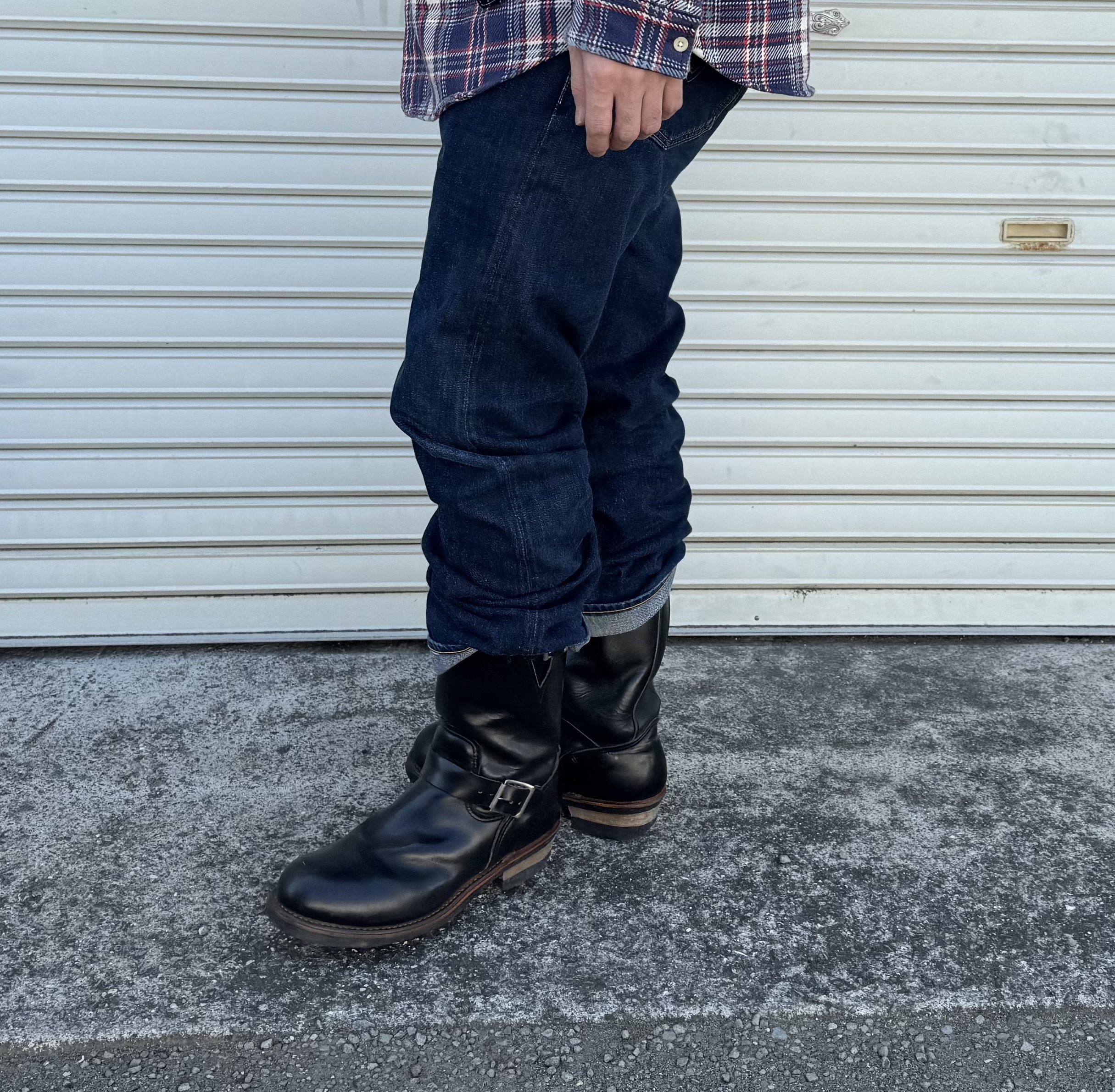 デニムの裾を無造作にロールアップしてエンジニアブーツのシャフトを見せるハングロールスタイル