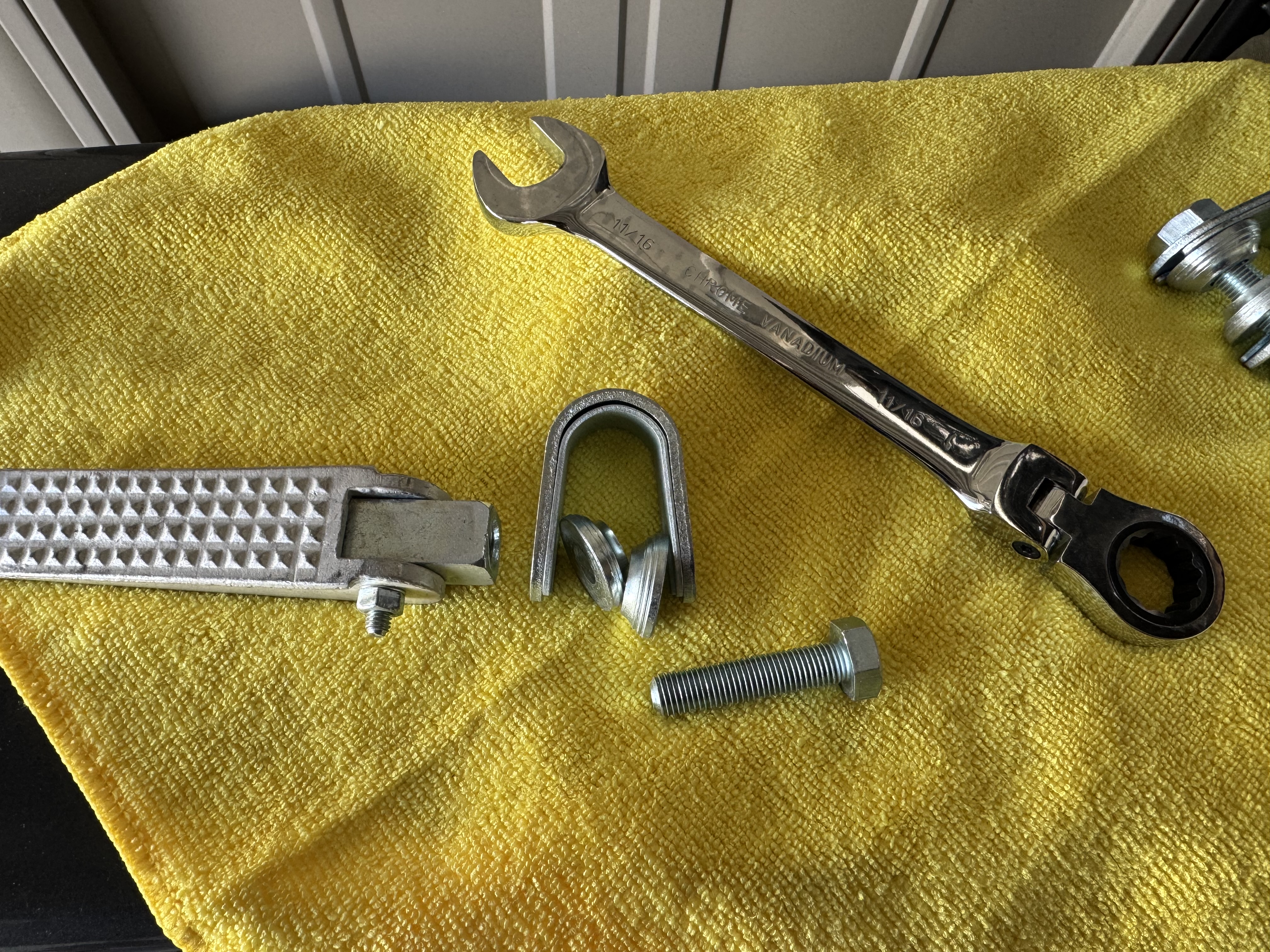 取り付けのために分解されたクランプステップのパーツと11/16インチのコンビネーションレンチ