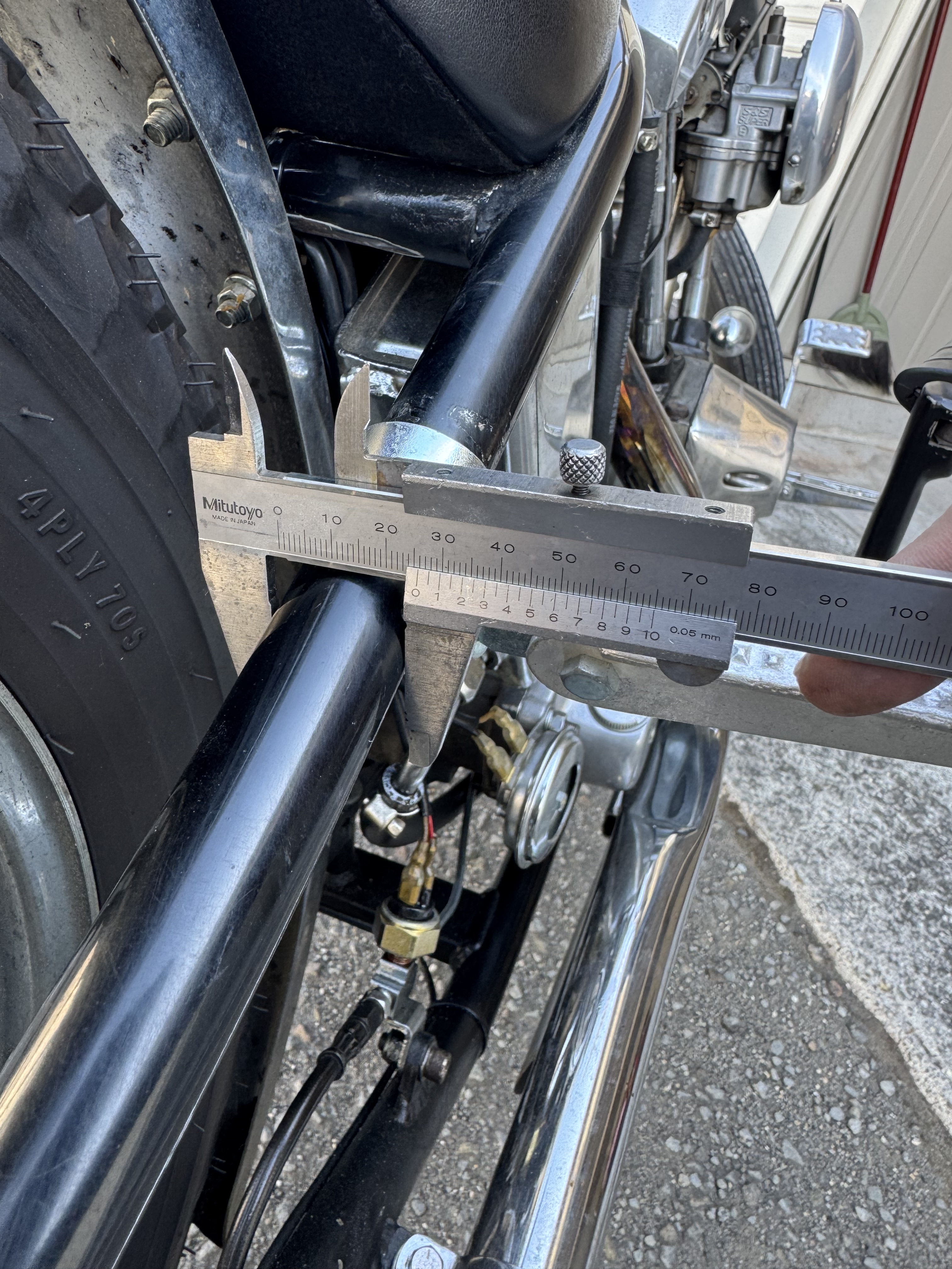 ノギスを使ってショベルヘッドのリジッドフレームのパイプ径を計測し、1インチ(25.4mm)であることを確認している様子