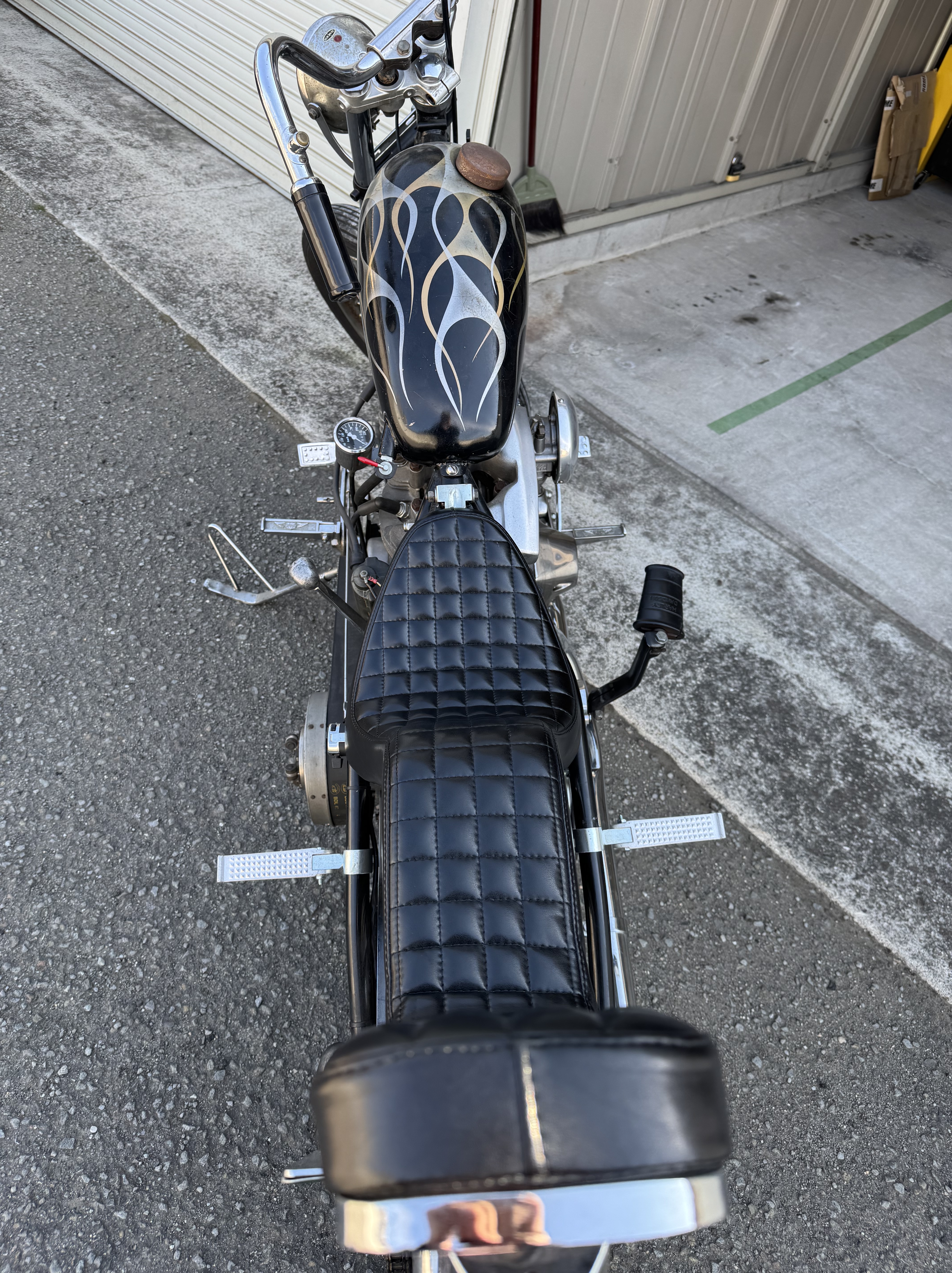 ショベルヘッドチョッパーを上から見下ろしたアングル。左右のフレームから張り出したアンダーソンタイプのクランプステップ