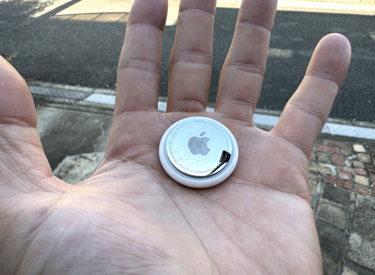 5年使用したAppleのAirTag本体を手のひらに載せたところ