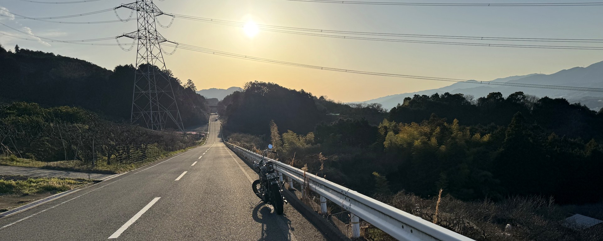 夕暮れの峠道とショベルヘッド プロフィールカードのヘッダー画像