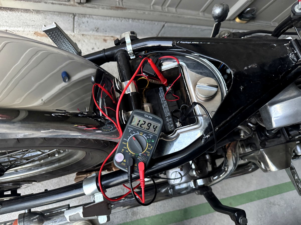 新しいバッテリーを搭載後に電圧を測定し12.94Vを表示したテスター
